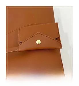 Detailed macro view of brown leather bag with fine stitching and gold snap button hardware