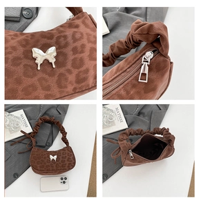 Detail view of leopard print shoulder bag with silver butterfly and pleated handle