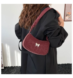 Close-up of burgundy hobo bag with leopard embossing and golden butterfly buckle