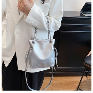 Detail view of silver chain bucket bag with metallic finish and drawstring closure