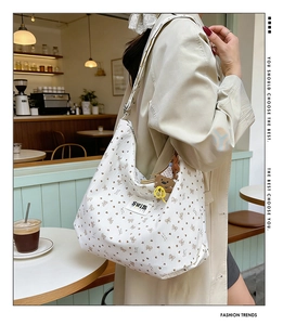 Detailed shot of beige corduroy tote bag with cute bear patterns in a cozy cafe setting
