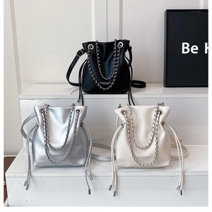 Three fashion bucket bags in black, silver, and white with elegant metal chain handles