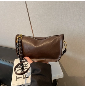 Close-up of vintage brown leather handbag with Fashion and Bag embossed lettering