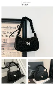 Detail of black leopard print underarm bag with silver butterfly buckle and pleated strap