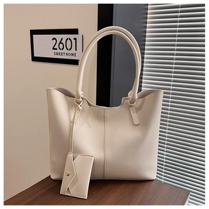 Close-up of cream large tote bag in smooth PU leather with matching small triangle pouch