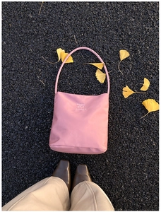 Detail der rosa Nylon-Einkaufstasche mit Hope and future Aufdruck auf herbstlichem Laub