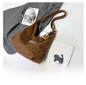 Detailed close-up of brown corduroy tote with bow prints and a cute bear plush keychain