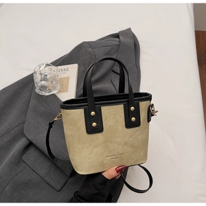 Détail du sac seau à la mode avec poignées en cuir et finitions de rivets dorés