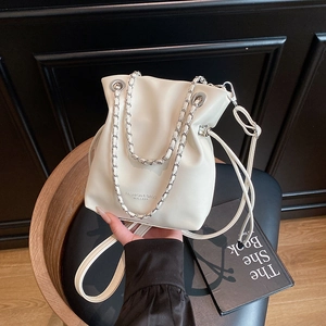 Creamy white drawstring bucket bag with silver chain strap and leather accents