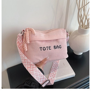 Detailed close-up of pink corduroy tote bag featuring a geometric woven shoulder strap