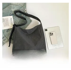 Macro shot of black and white checkered canvas tote bag with wide shoulder strap