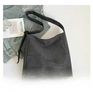 Detail of minimalist black and white checkered canvas tote bag with adjustable shoulder strap
