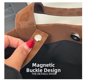 Detailed close-up showing the magnetic snap closure on the brown faux leather tote bag