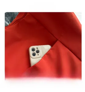 Gros plan détaillé d'un grand sac fourre-tout rouge avec une poche extérieure pour téléphone