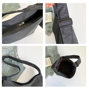 Detail of checkered canvas crossbody bag with adjustable strap and metal zipper closure