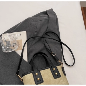 Vue de dessus d'un sac seau bicolore avec détails dorés et finitions en cuir noir