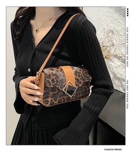 Close-up of leopard print shoulder bag featuring a gold square buckle and leather strap
