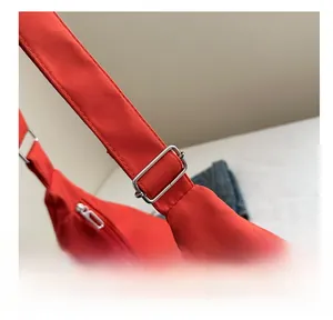 Détail du sac cabas en nylon rouge avec boucle argentée réglable et couture de fermeture