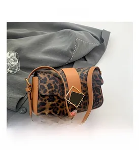 Detail of leopard print shoulder bag featuring premium brown leather trim and metal clasp