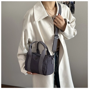 Close-up of charcoal grey nylon barrel bag featuring dual handles and adjustable wide strap