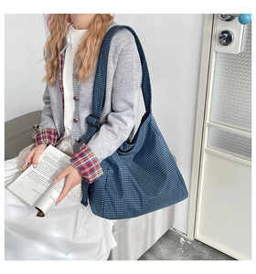 Detail view of blue and white checkered tote bag with adjustable black buckle strap