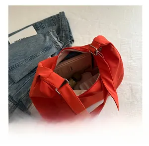 Vue détaillée montrant la grande capacité du sac fourre-tout en nylon rouge avec objets