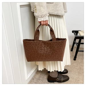 Detail of a large brown leopard print tote bag in soft fabric for stylish autumn outfits