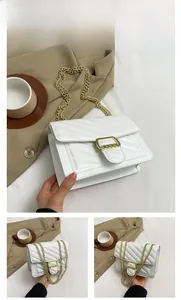 Detailed view of white quilted faux leather bag with V-shaped stitching and gold chain