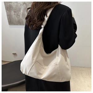 Détail du grand sac cabas crème avec coutures diagonales et bandoulière ajustable