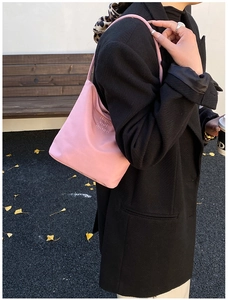 Pink nylon underarm bag with Hope and Future embroidery on casual street background