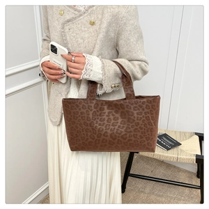 Close-up of leopard print tote bag paired with an elegant autumn outfit for women