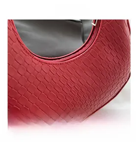 Macro shot of red crocodile embossed faux leather texture and metallic zipper details