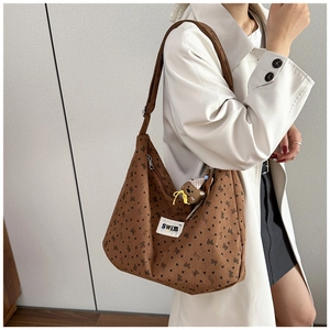 Detail of brown corduroy hobo bag featuring heart patterns and white SWIM label