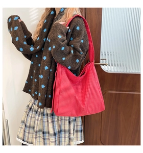 Detail of red and white checkered canvas tote bag styled with a vintage aesthetic