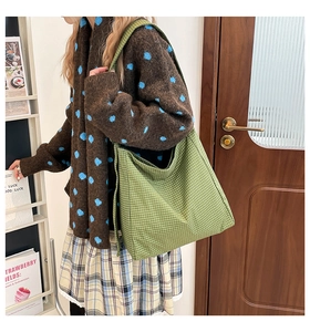 Detailed texture of green checkered canvas tote bag with woven fabric on a model side view