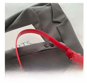 Close-up of the red woven PU leather texture and silver zipper detail of this hobo bag