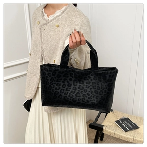 Close-up of leopard print tote bag with black suede texture and sturdy double handles