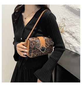 Detail of leopard print shoulder bag with brown leather trim and golden geometric buckle