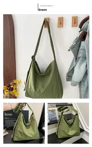Detail view of green plaid canvas tote bag showing adjustable strap and soft fabric texture