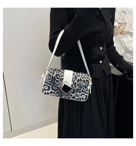 Detail of leopard print shoulder bag with white straps and geometric metal buckle