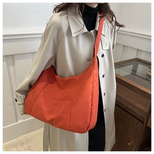 Vue détaillée du grand sac hobo orange montrant la texture du tissu en nylon léger