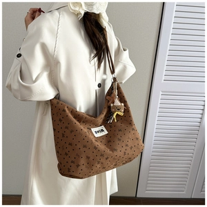 Detail view of brown corduroy tote bag with butterfly prints and heart patterns