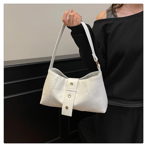 Detailed close-up of white PU leather shoulder bag with decorative golden rivets