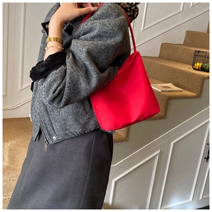 Detailaufnahme einer roten Hobo-Tasche aus Nylon mit Goldkette und geprägter Textur