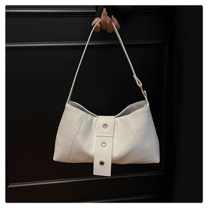 Detail of white PU leather underarm bag featuring minimalist gold ring rivet decorations