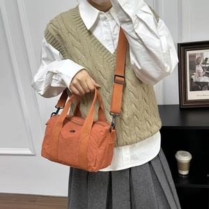 Minimalist orange washed canvas messenger bag for women with nylon fabric and logo detail