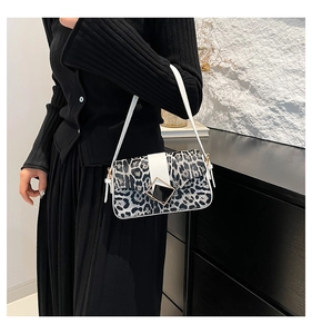 Close-up of leopard print shoulder bag with white leather strap and metal buckle