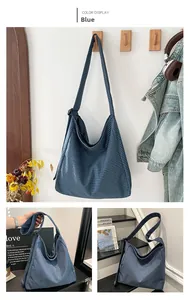 Detail view of large blue checkered canvas tote bag with adjustable wide shoulder strap