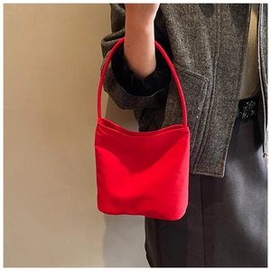 Detailansicht der roten Nylon-Hobo-Tasche kombiniert mit grauem Mantel für Pendler