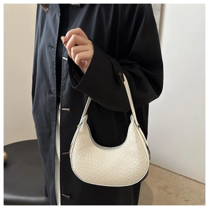 Detail shot of white woven texture on a minimalist crescent hobo shoulder bag for women